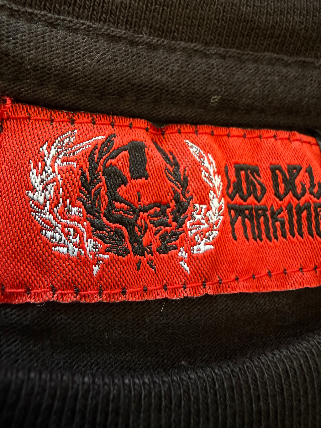 detalle de la etiqueta de cuello de parking warriors en la camiseta newstyle warrior negra